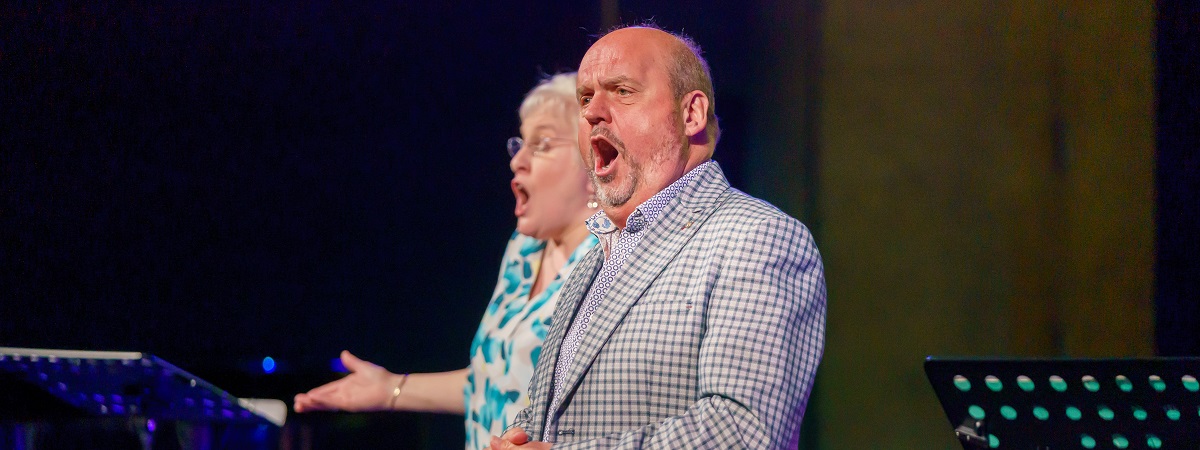 Opera singers Graeme Danby and Valerie Reid perform on stage.